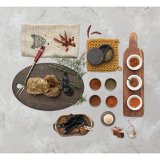 Chipotle BBQ Seasoning on a rustic gray surface with several spice bowls and a chicken leg.