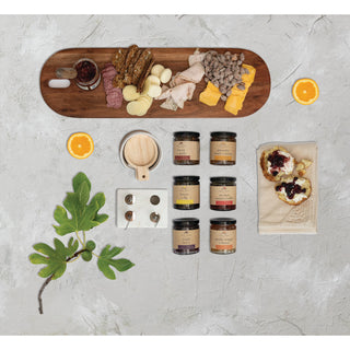 Bacon Apple Jam on a wooden charcuterie board with six glass jam jars, meats, cheeses, and citrus.