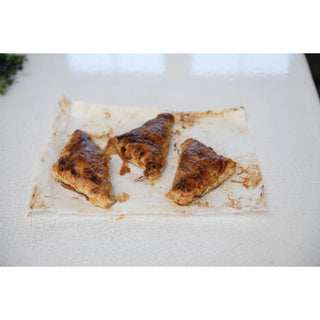 Bacon Apple Jam pastries on parchment, three golden-brown turnovers