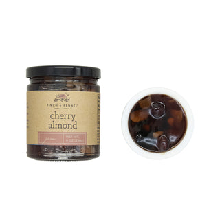 9 oz cherry almond jam jar with kraft label and black lid, shown beside a cup of jam.