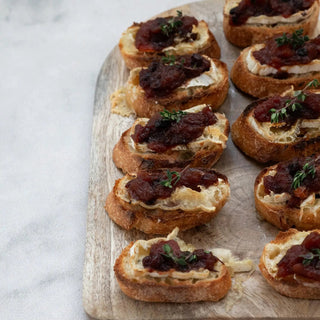 Cranberry chutney crostini bites on a rustic wooden board