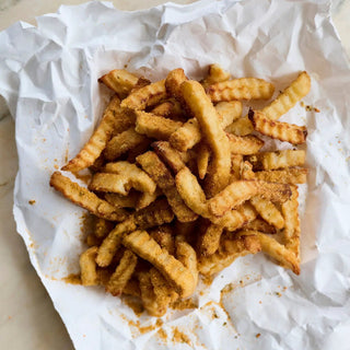 That's Amore Topper Seasoning on crinkle-cut fries with a golden-brown, seasoned coating
