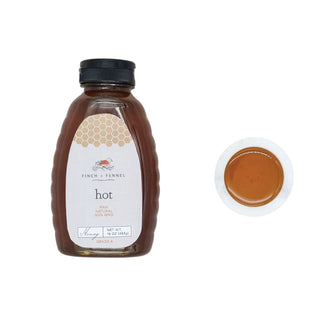 Hot honey bottle, 16 oz Grade A, amber plastic with black cap beside a white dish of honey.