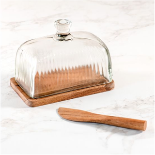 Butter dish with glass lid on a wooden base and a wooden knife