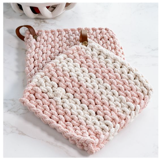 Knit pot holder in light pink and white stripes with a leather loop.