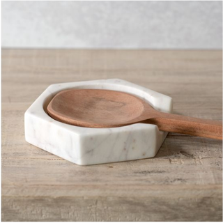 Marble hexagon spoon rest in white marble with wooden spoon.