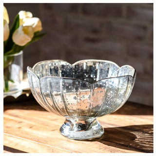 Metallic finish scalloped bowl on a pedestal base with a reflective hammered surface.