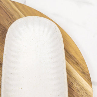 10-inch white speckled ceramic oblong platter on a wooden serving board