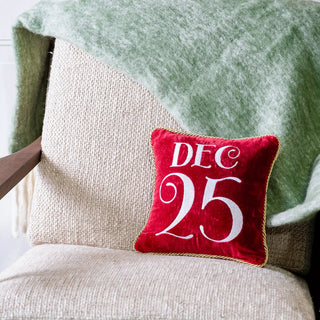 Red velvet December 25 pillow with gold rope trim.
