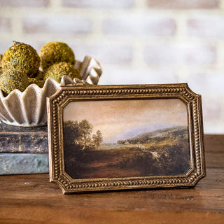 Antique gold dot-edge frame with beaded border enclosing a landscape painting.