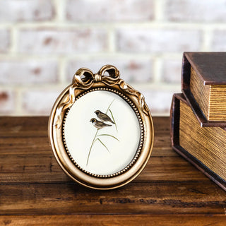 Round gold bow frame with ornate beaded edge and vintage finish
