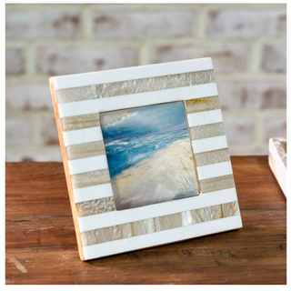 Beige striped resin photo frame with white bands surrounding a beach scene photo
