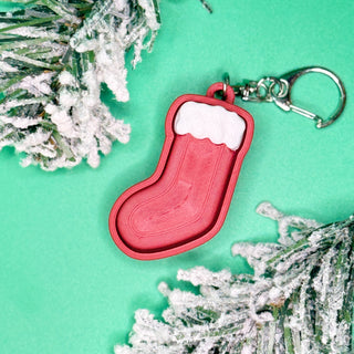 Red stocking-shaped keychain with white fur trim

