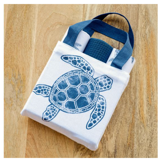 Turtle towel with bag, white tote with blue turtle graphic and blue handles; rolled blue towel inside.