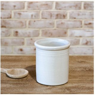 White ceramic canister vase with a glossy glaze on a wooden surface.