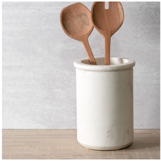 White marble jar with two wooden spoons on a light wooden surface