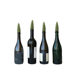 Tree-shaped bottle taper candles, unscented green, four placed on wine bottles.