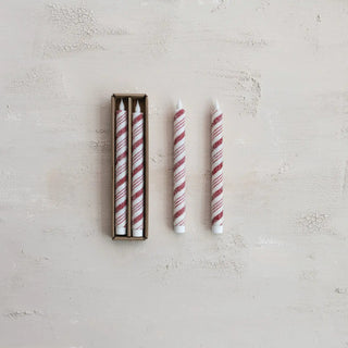 Set of four flameless LED taper candles in red-and-white stripes in a cardboard box.