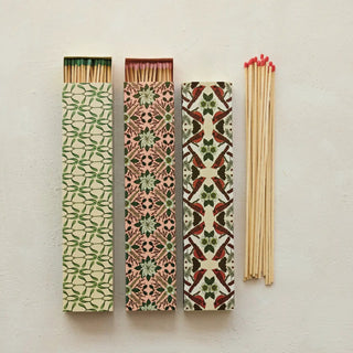 Safety fireplace matches in botanical matchboxes; green leaf, pink floral, red-bird designs with wooden matches.