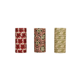 Three decorative matchbox tubes with seasonal botanical patterns: red poinsettia, pink floral, and olive motifs.