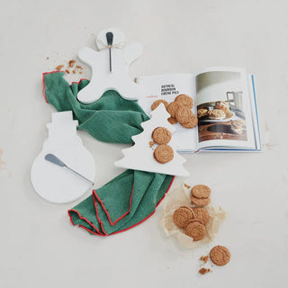 Tree-shaped white marble trivet serving board with cookies; open cookbook seen nearby.