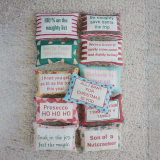 Cotton embroidered lumbar pillows with red and white striped fronts and festive holiday phrases