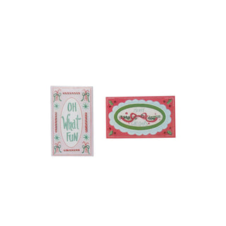 Two safety matches in embossed matchbox packaging with holiday designs; left reads Oh What Fun, right Merry Christmas.