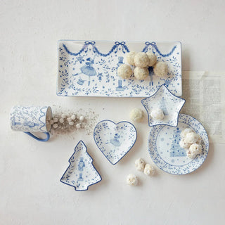 Blue-and-white ceramic serveware set with holiday motifs, including a rectangular platter and star and heart dishes.