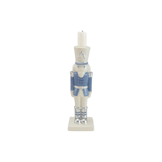 Nutcracker-shaped ceramic taper candle holder in white and blue with silver accents.