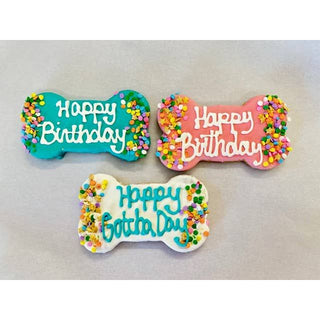 Dog bone-shaped cookies with Happy Birthday icing in teal, pink, and white with colorful sprinkles - set of three