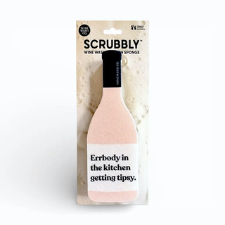 Scrubbly bottle-shaped sponge in blush pink on wine-themed packaging with the text Errbody in the kitchen getting tipsy