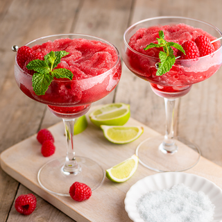 Very Berry Raspberry Wine Slushy Mix; two red slushy cocktails garnished with raspberries and mint
