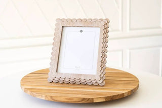 Wood scallop photo frame for 8x10 photos, natural wood finish on a round table.