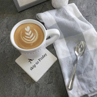 Drink Coaster Alexa skip to Friday design under a white latte cup on a gray stone surface with a striped napkin