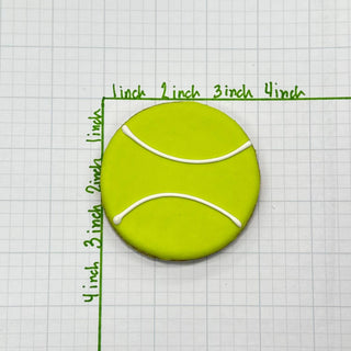 Sports Ball Buffet Cookies: round lime-green cookie with white curved icing lines.