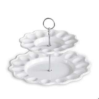 White ceramic two-tier egg server on a pedestal with beaded edge and a silver ring handle