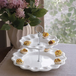 Two-tier egg server pedestal in white ceramic with scalloped rims and central handle