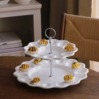 Two-tier egg server on a pedestal, white ceramic with beaded edges and a silver ring handle.