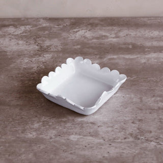 Beverage napkin holder, white with scalloped-edge sides, square shape.