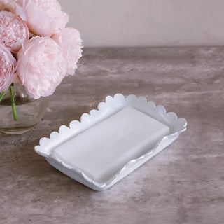 Colette guest towel holder in white ceramic with scalloped edge, placed beside pink peonies.
