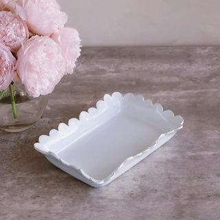 Guest towel holder in white ceramic with scalloped edges, a simple, elegant bathroom accessory.