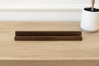 Pair of espresso wood tile stands, 12-inch length, laid flat on a light wood desk surface.