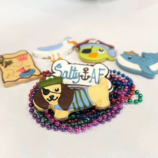 Pirate Salty AF Bone cookie for dogs, bone-shaped with green pirate hat, eyepatch and colorful icing beads around