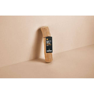 Dog chew stick made of coffee wood, light brown with black label.