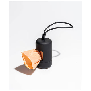 Poop bag dispenser, black plastic with a looped cord and a peach bag protruding from the opening.