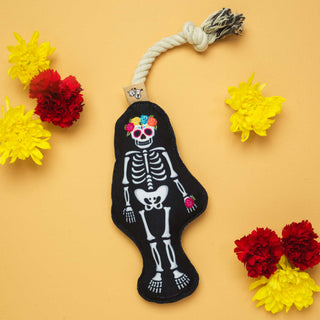 Rope dog toy featuring a Day of the Dead skeleton on black fabric, bone-shaped design