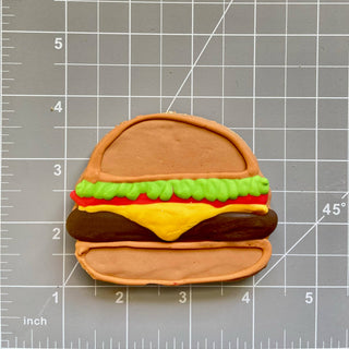 Lunch Menu Dapper hamburger-style dog treat with green lettuce, red tomato, yellow cheese and bun