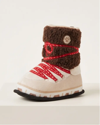 Apres Ski Boot dog toy with brown fleece cuff, red laces, beige body, paw logo patch, squeaker.
