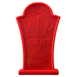 Headstone-shaped red nylon dog chew toy with RIP HERE LIES THE BONE YARD engraving for Halloween