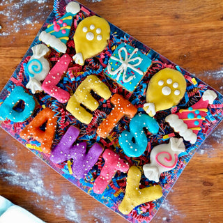 Gift box of PAWTY Birthday dog treats with colorful letter cookies and festive shapes